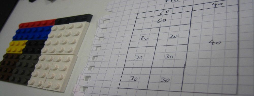 Photograph of a handdrawn grid next to the same grid arranged with Lego pieces.