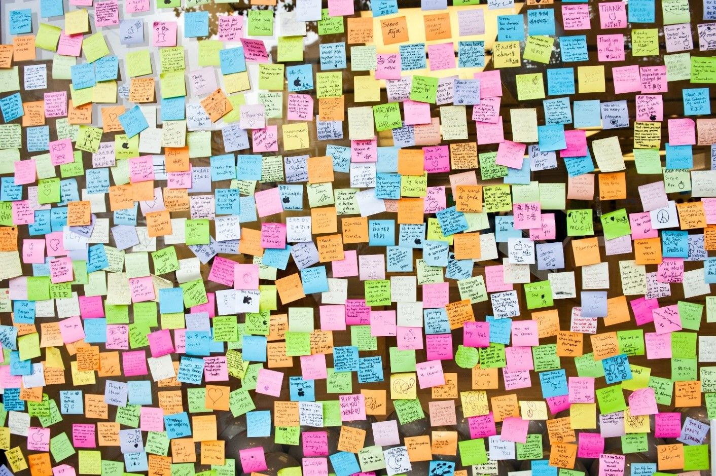 Lots of sticky notes on a wall.