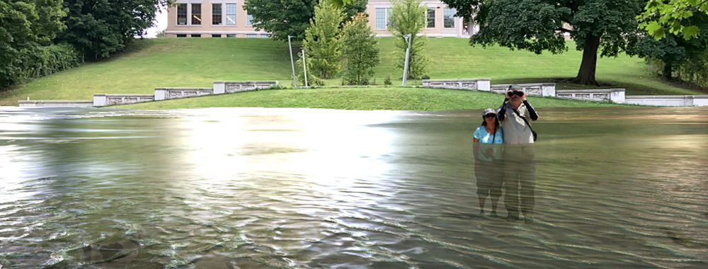An augmented reality display of rising water around real people as they observe the landscape around them.