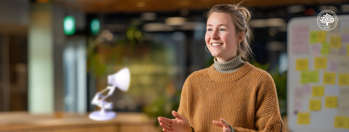 Smiling woman presenting in a modern workspace with a Pixar-style lamp and sticky notes, representing storytelling in presentations.