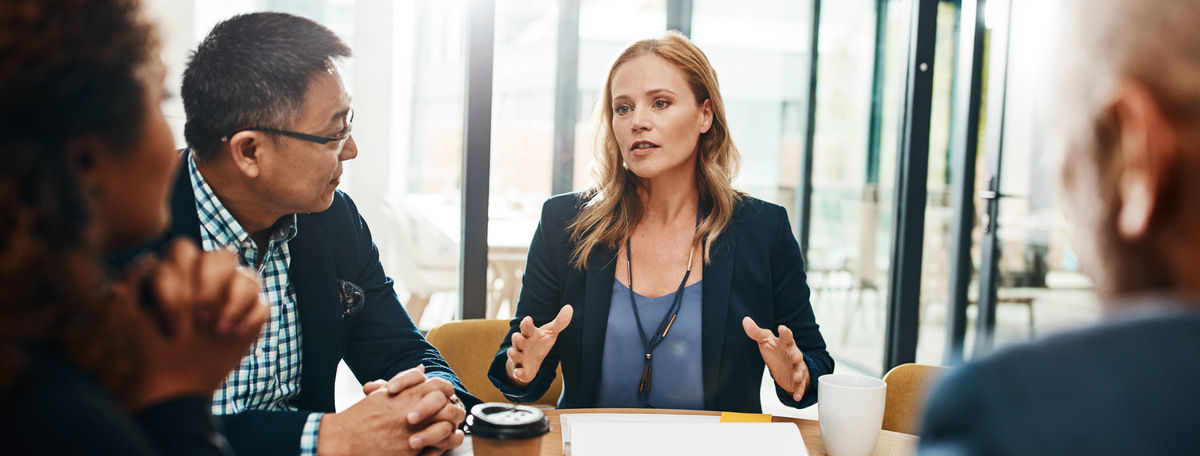 A calm, confident woman presenting to colleagues in a professional setting, demonstrating the high-impact presentation skills that lead to career promotions.