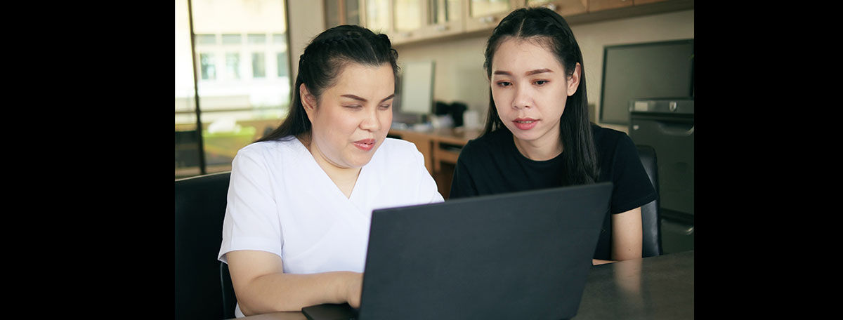 Blind test participant sitting at laptop next to colleague