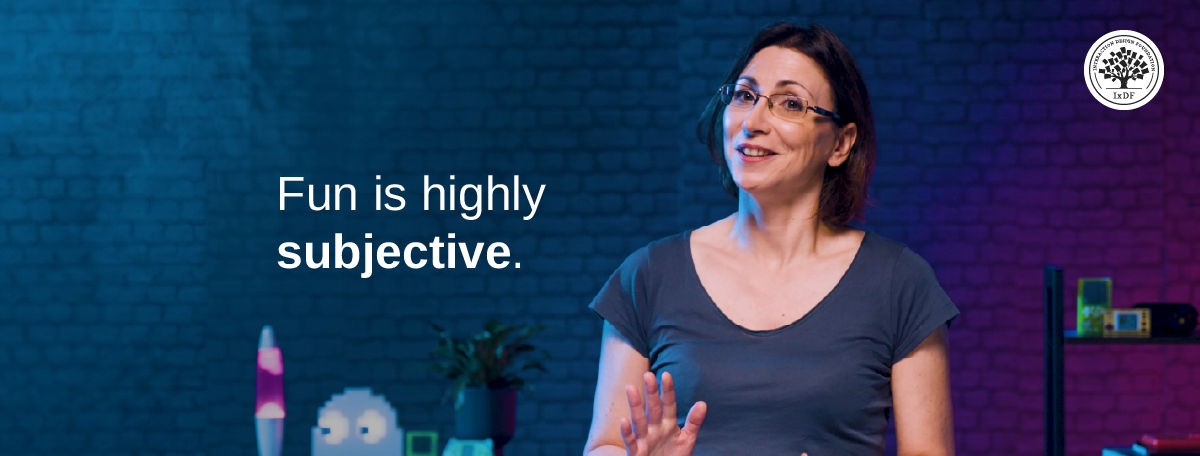 Celia Hodent stands in front of a purple and blue background with the text "Fun is highly subjective"
