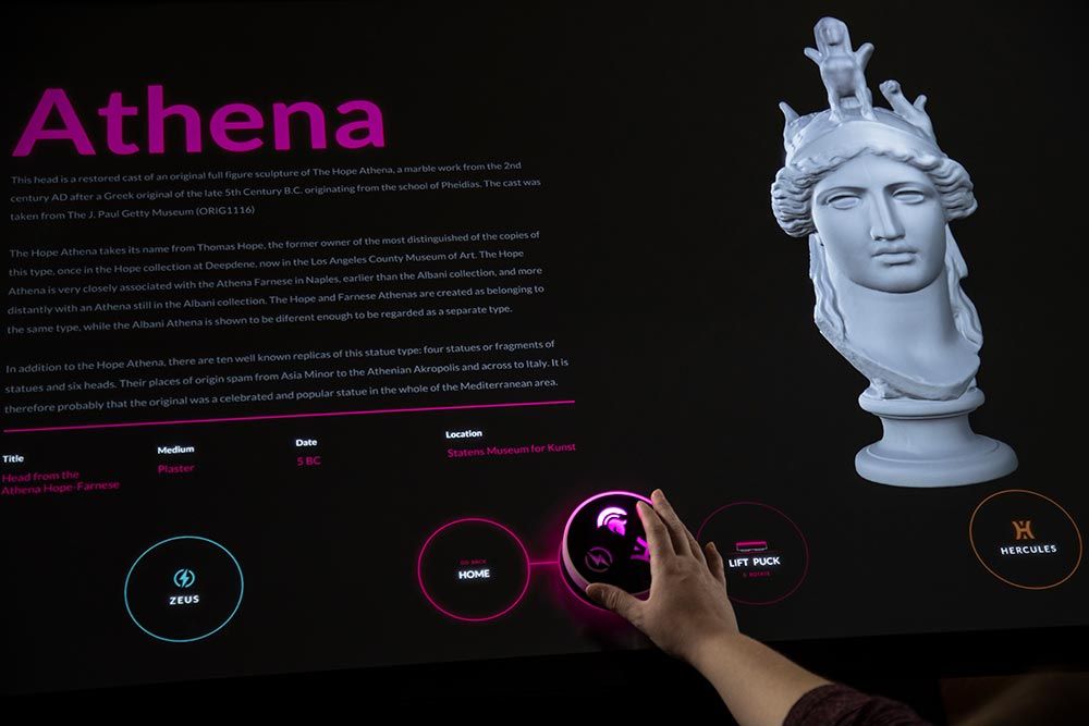 An image of an interactive display featuring a Greek goddess and showing a puck in use.