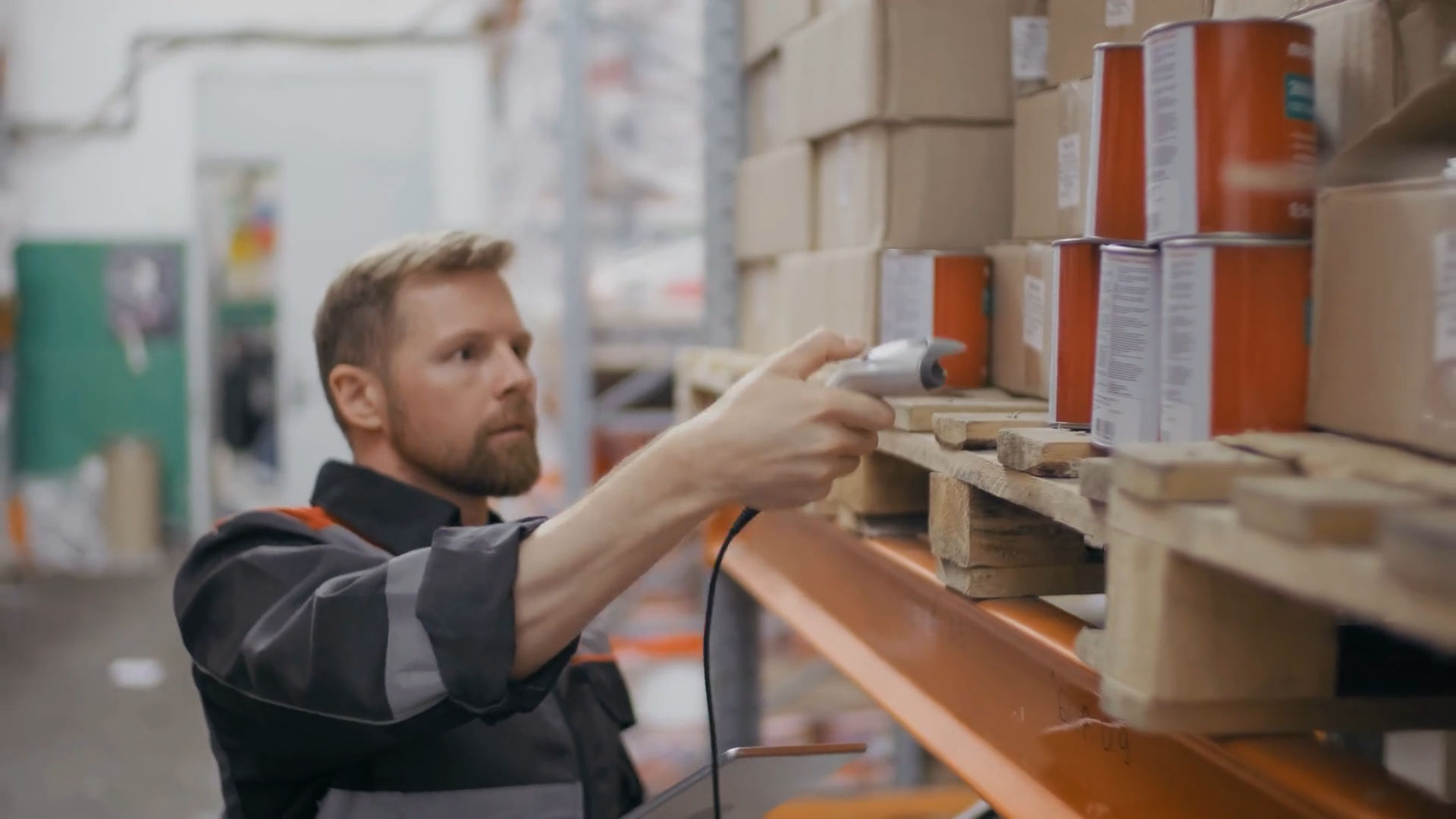 Warehouse worker scanning bar codes with portable reader.