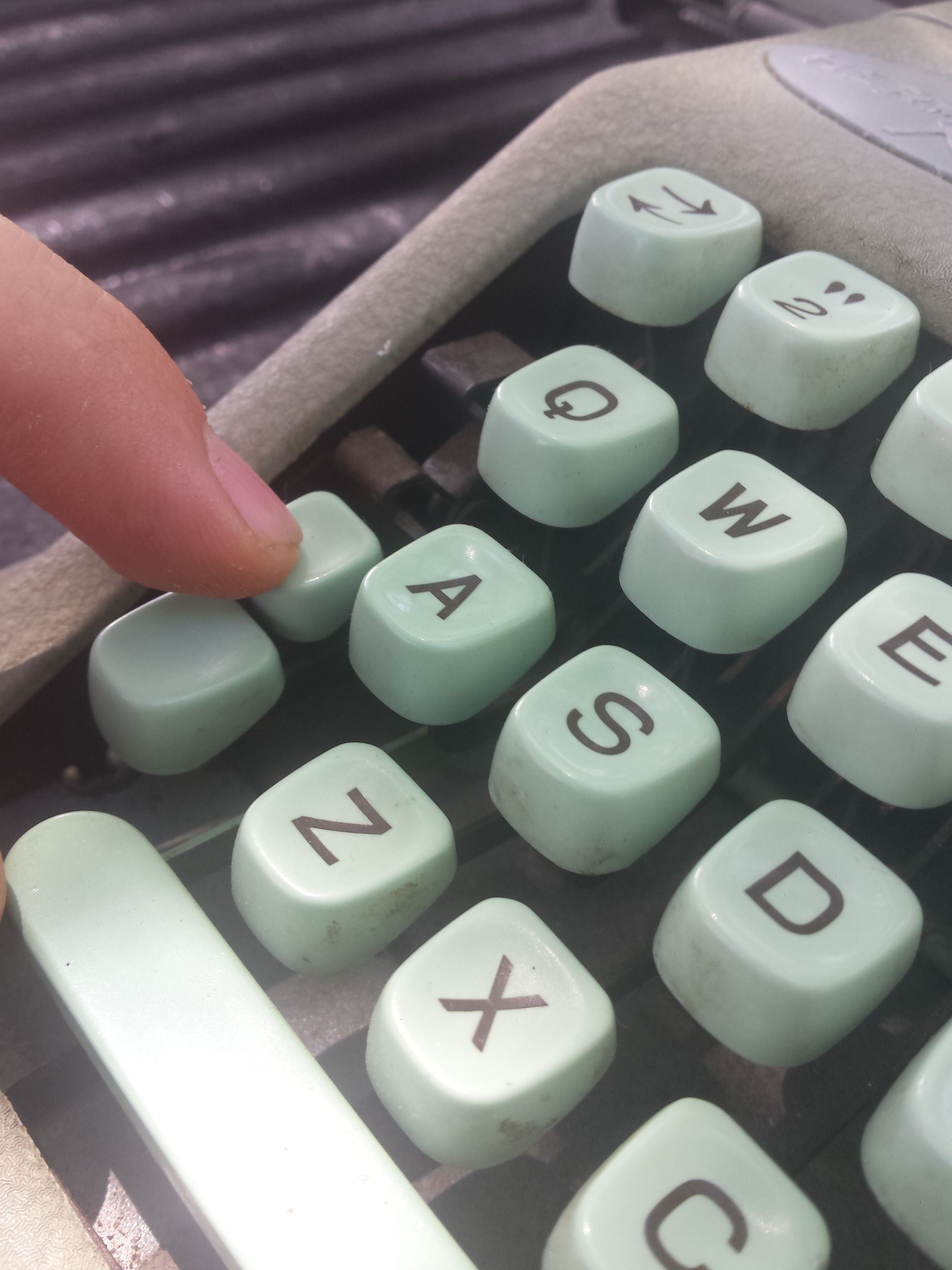 A close-up image of a typewriter, featuring some keys and the space bar.