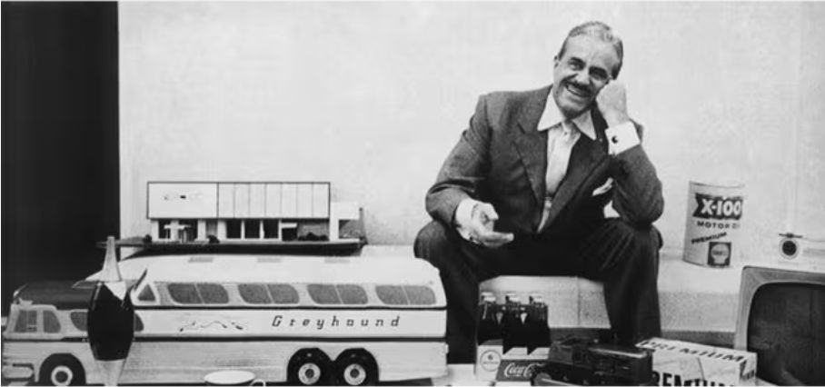 An image of Raymond Loewy sitting with some designed objects. 