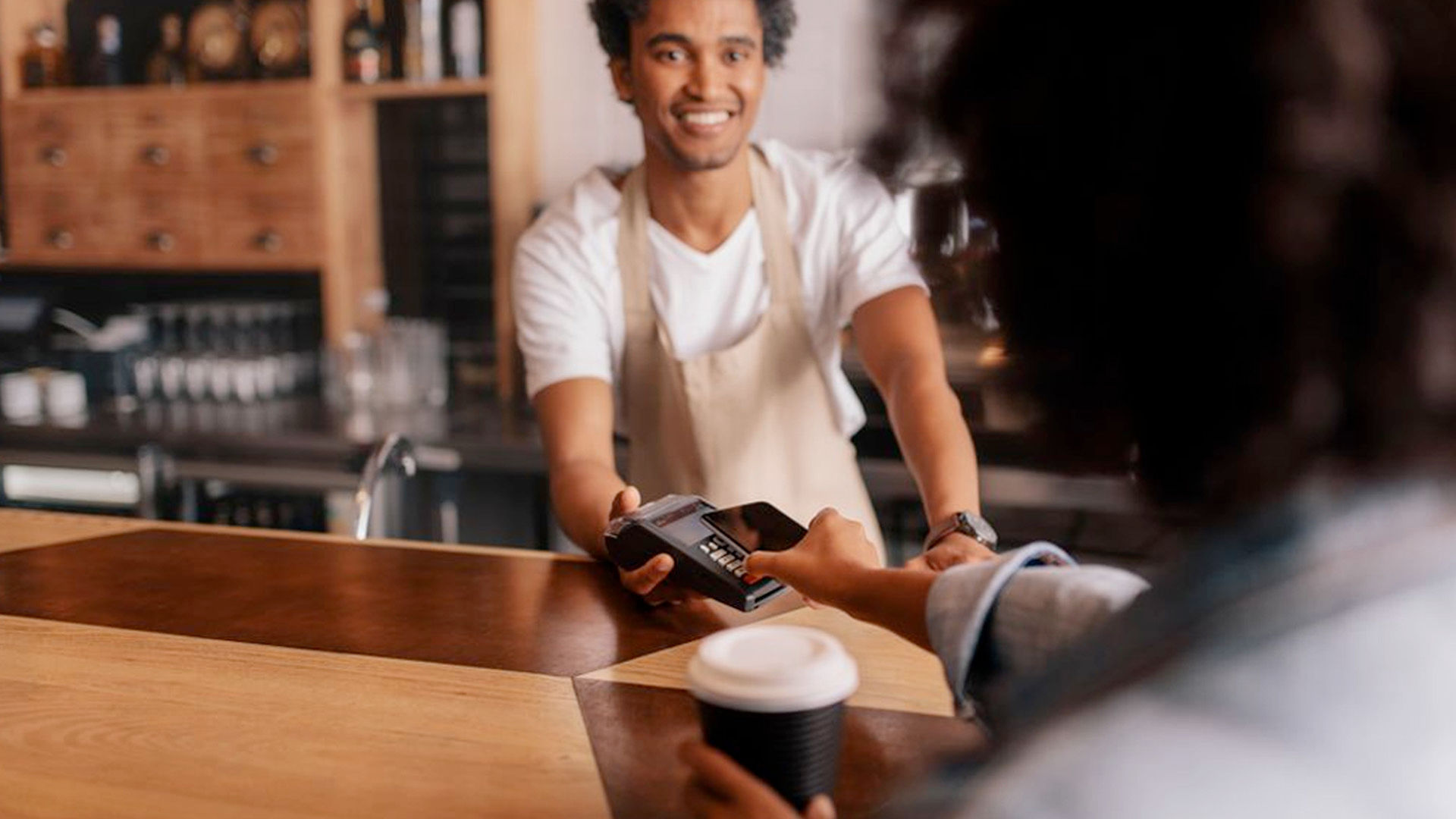Image of a staff member serving a customer in a shop with a point of sale system.