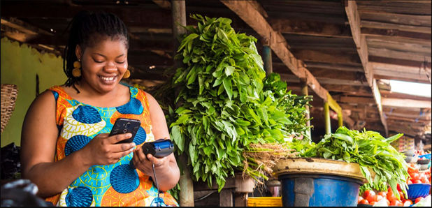 Women smiling with a mobile phone and portable card machine. 